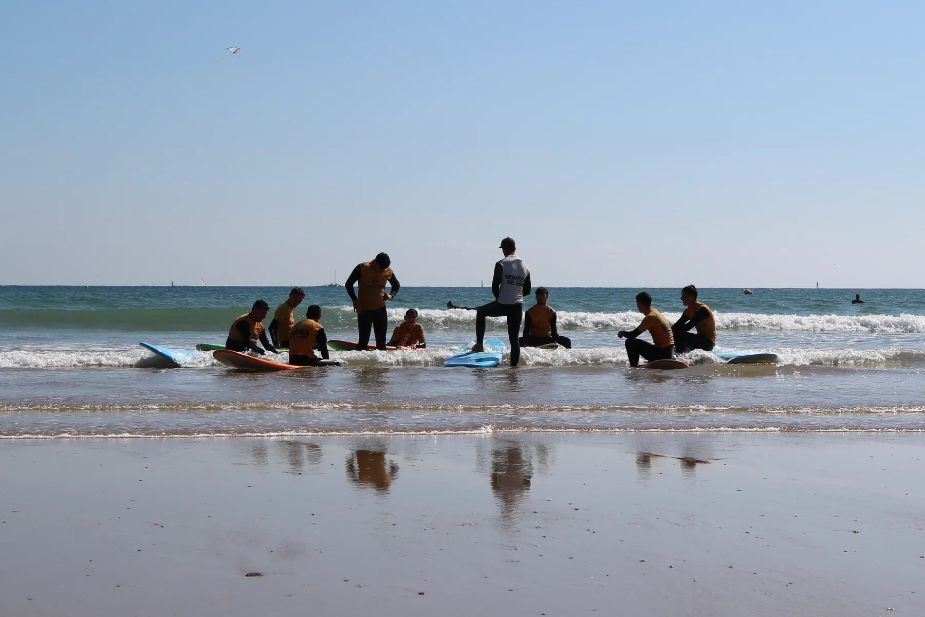 Le groupe rassemblé autour du moniteur au bord de l’eau, assis sur les planches, à la fin de la séance.